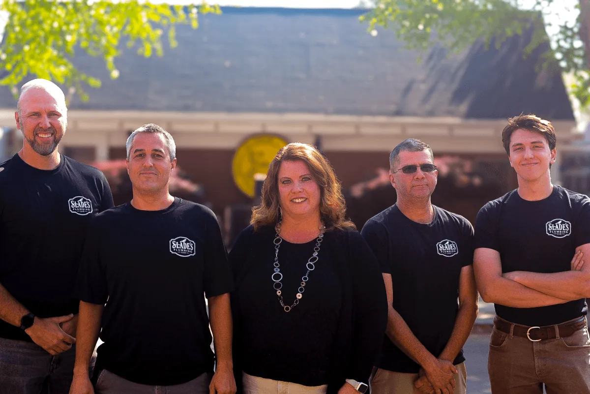 The Slade's Plumbing team standing together outside in matching Slade's Plumbing shirts